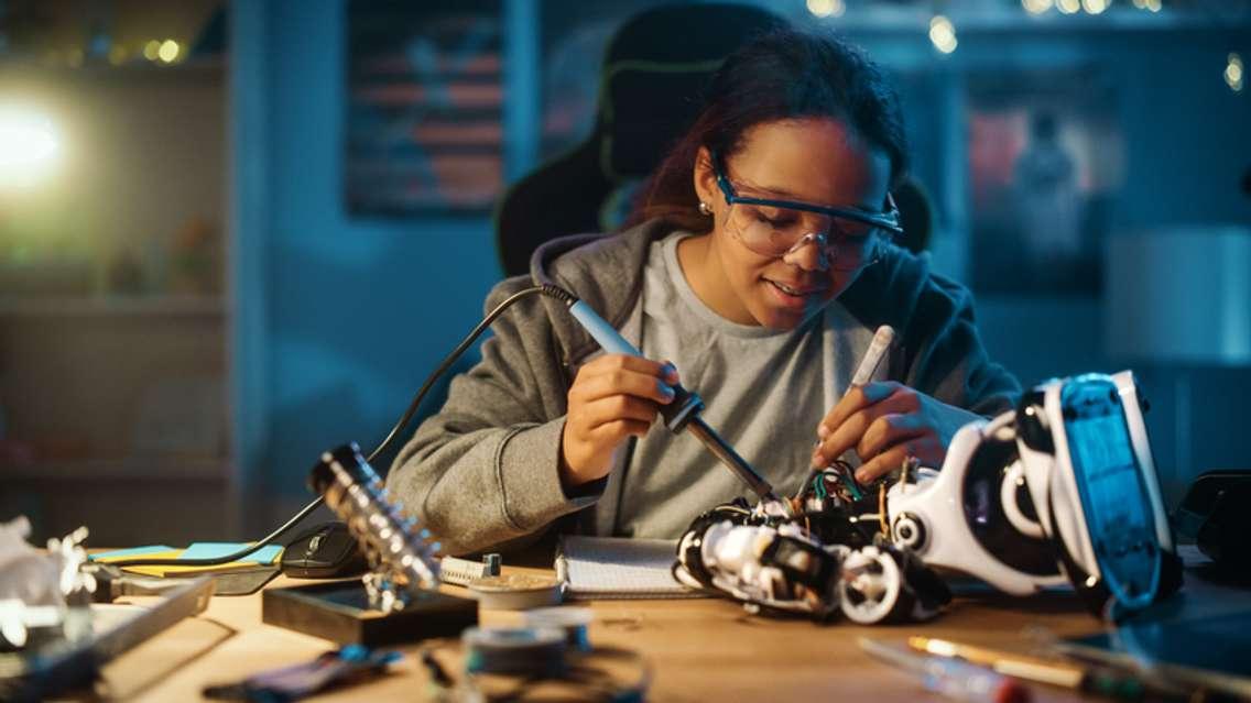 A young women soldering wires and circuit boards. (Image from gorodenkoff / iStock / Getty Images Plus / via Getty Images)