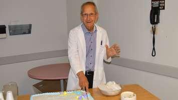 Dr. Gary Gurbin cuts the cake during a ceremony to honour his 50 years
of practicing medicine in Kincardine.
