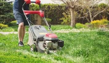 Photo of a man mowing the lawn by Ablozhka via iStock / Getty Images Plus