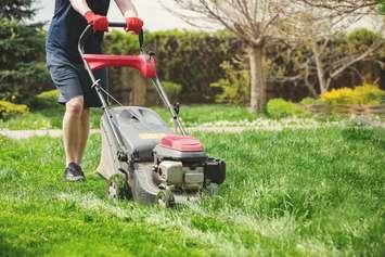 Photo of a man mowing the lawn by Ablozhka via iStock / Getty Images Plus