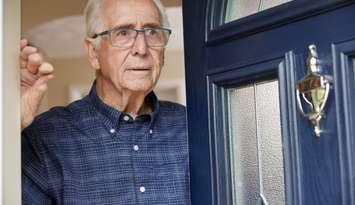 senior answering door (Photo courtesy of Daisy-Daisy / Royalty-free / iStock / Getty Images Plus)