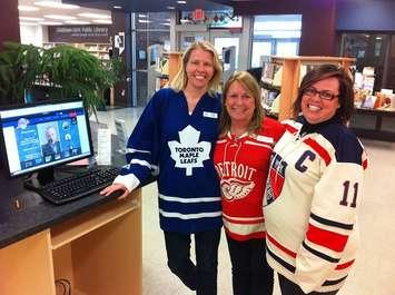 Chatham-Kent Public Library staff members (L to R) Heidi Wyma, Marie Broadbent, and Sarah Hart sport their NHL jerseys at the designated Kraft Hockeyville voting station. (Photo by Mike James)