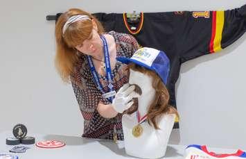 Lambton Heritage Museum Curator/Supervisor Dana Thorne considers the placement of a moustache for a display about the 1979 and 1981 Allan Cup champions, the Petrolia Gibbons-Squires. Submitted photo.