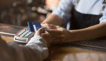 Cashier getting paid by credit card (Image by fizkes / iStock / Getty Plus Images via Getty Images)