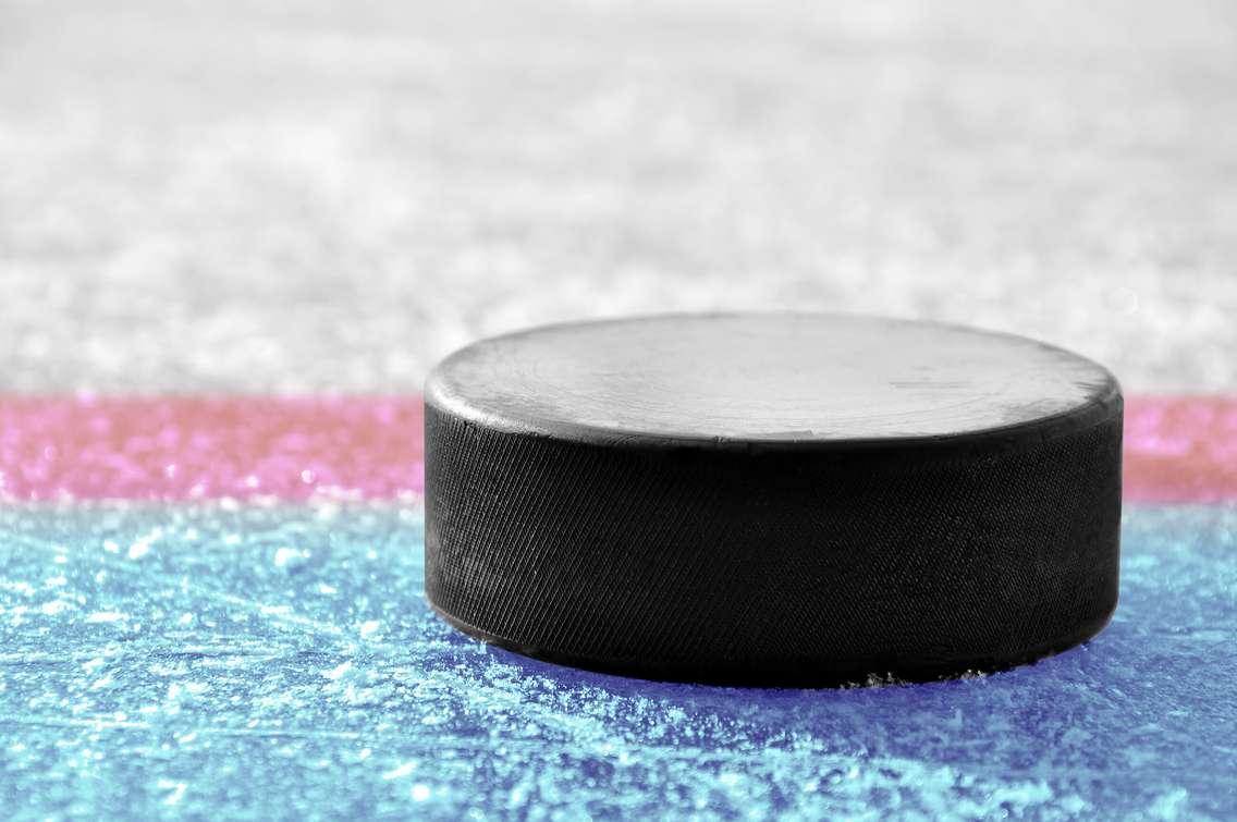 A hockey puck on an ice surface. © Can Stock Photo / vencavolrab