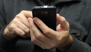 A person on a smartphone. File photo courtesy of © Can Stock Photo / portosabbia