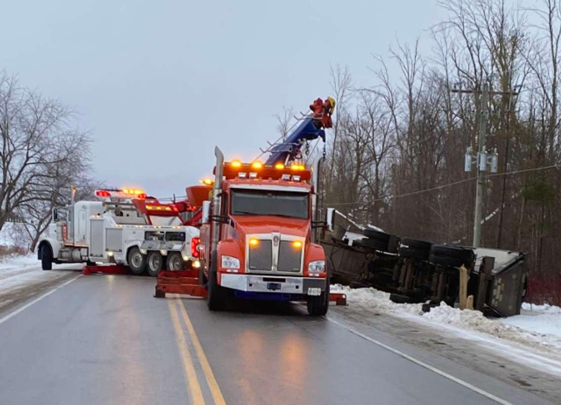 Tow trucks work to flip an overturned transport truck back onto its wheels on Perth Line 44, February 3, 2025. Photo provided by Perth OPP.