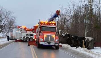 Tow trucks work to flip an overturned transport truck back onto its wheels on Perth Line 44, February 3, 2025. Photo provided by Perth OPP.