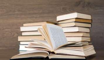A stack of books sitting on a table. File photo courtesy of © Can Stock Photo / Pakhnyushchyy.