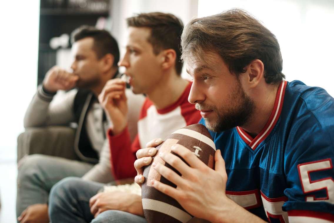 People watching a football game stock photo (Photo by: gpointstudio/  iStock / Getty Images Plus) 