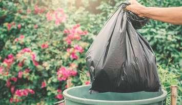 A garbage bag gets thrown out. 