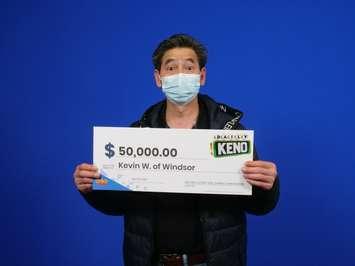 Kevin Wu of Windsor displays his $50,000 prize cheque at the OLG Prize Centre in Toronto, April 7, 2022. Photo provided by Ontario Lottery and Gaming.