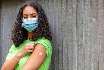 A young person in a mask who just received a vaccination. © Can Stock Photo / DarrenBaker