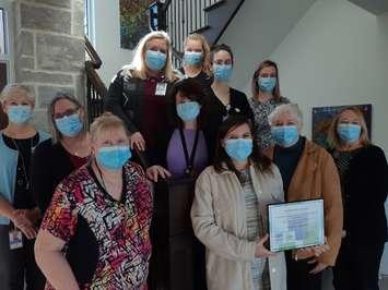 Jessica Smith, Executive Director, holds a plaque recognizing Chatham-Kent Hospice's accreditation as a Hospice Residence with Margaret Anderson, Chair of the Chatham-Kent Hospice Board of Directors, (to Jessica’s left) and Hospice team members. (Photo submitted by the CK Hospice)