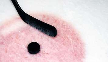 Hockey sport background: graphite stick and puck on real arena used and scratched ice.© Can Stock Photo / Mirage3