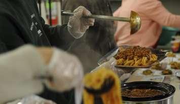 People prepare plates of spaghetti at a Salvation Army soup kitchen. Feb. 25, 2014. (Photo by Levin Boland)