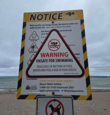 A sign advises the water at a Huron County beach is unsafe for swimming. Photo provided by @HuronBeachInfo on X
