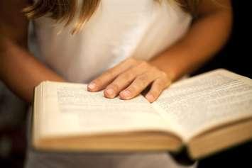 A woman reads a book. Photo courtesy of © Can Stock Photo / OlegKalina