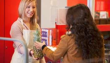 A cashier at a grocery store serving a customer. 
© Can Stock Photo / Leaf