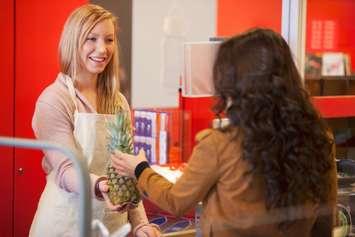 A cashier at a grocery store serving a customer. 
© Can Stock Photo / Leaf