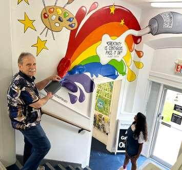 Arts donor and supporter Merv Redman, of Kitchener, has fun with a new interactive mural in the foyer of the Southampton Art Gallery, on High St. in Southampton. Photo from Community Foundation Grey Bruce