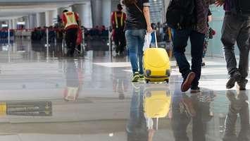 Travellers walk through the corridor of an airport. File photo courtesy of © Can Stock Photo / pongsakorn26