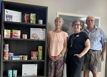 Co-Chair of the Town of Minto’s Diversity, Equity and Inclusion Committe Jokelee Vanderkop,  Wellington County Library Branch Supervisor – Palmerston Kayleigh Armstrong, Co-organizer of the Anderson's Annual Community Christmas Dinner and County Councillor David Anderson, beside the Palmerston community food pantry. Photo provided by the County of Wellington.