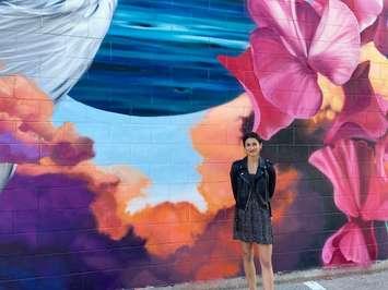 Artist Meaghan Kehoe in front of the new mural on the side of the Bayfield Arena. (Photo by Bob Montgomery)

