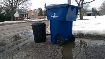 A Progressive Waste Solutions garbage toter (right) stands beside a standard garbage pail. March 15, 2015. (Photo by Matt Weverink)