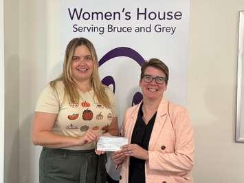 Danielle Bois,Community Relations and Fund Developer for the  Women’s House Serving Bruce and Grey, receives a $5,000 donation from Sarah Foster, Race  Director of the Lakeshore Triathlon, from this year’s race proceeds. Photo from Sarah Foster