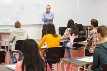 Students listening to teacher in a classroom. File photo courtesy of © Can Stock Photo / 4774344sean