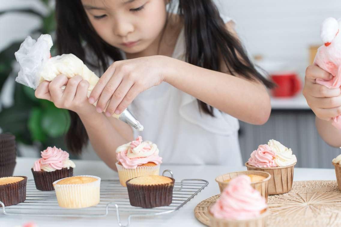 A little girl decorating cupcakes. File photo from Pruksachat Lapvilai/ iStock / Getty Images Plus