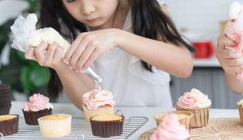 A little girl decorating cupcakes. File photo from Pruksachat Lapvilai/ iStock / Getty Images Plus