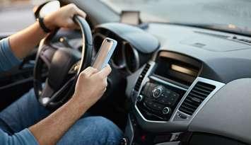 Someone texting and driving stock photo. (Photo by: perfectlab/ iStock/ Getty Images Plus)