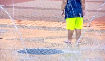 Child playing in spray pad. Photo courtesy of © Can Stock Photo / liveslow