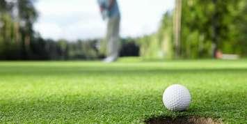 Golfer putting on the green. File photo courtesy of © Can Stock Photo / Deklofenak