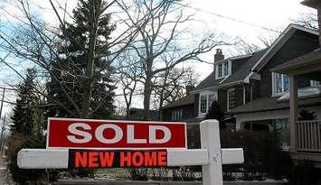 A home with sold sign. File photo courtesy of © Can Stock Photo / Elenathewise