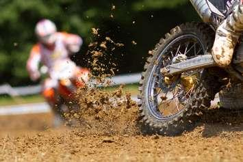 Bike throwing mud in a motocross race. © Can Stock Photo Inc. / stefanschurr