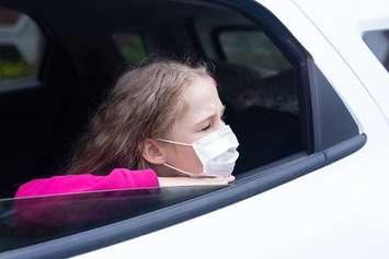A child with a face mask waits inside a vehicle. File photo courtesy of © Can Stock Photo / NataliaDuryagina