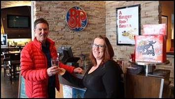 Mayor Ian Boddy enjoys a glass of cold water handed to him by server Christina Goheen at Boston Pizza