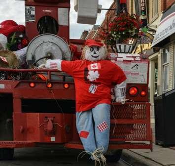 Scarecrow Dan waits for a hoist up a lamppost in downtown Meaford during the red-and-white invasion to celebrate Canada’s 150th.  (photo submitted)
