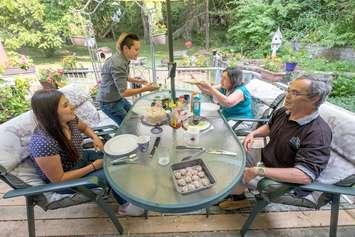 The Staples (right) and their Homestay guests (left) enjoy breakfast on the back deck. Family meals are a big draw for international students looking for accommodations through the Homestay program. (Georgian College / Doug Crawford)