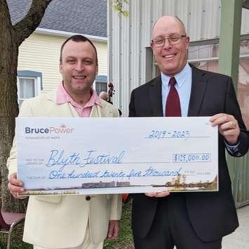 Gil Garratt, left, Artistic Director of the Blyth Festival, and Chris Mercanti, Manager of Community and Indigenous Relations, Bruce Power, with the cheque cementing Bruce Power's contribution to the Festival for the next 5 seasons. June 17th, 2019 (Photo submitted by Dwight Irwin, Communications Specialist – Corporate Communications-Bruce Power)