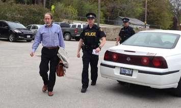 South Bruce Peninsula Councillor Craig Gammie [Left] is lead from town
hall by OPP officers. Photo by Jordan MacKinnon.