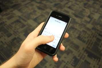 A person sending a text message. (File photo by Blackburn News)