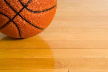 A basketball on a gym floor. © Can Stock Photo / mflippo