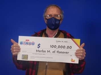 Merlin MacKinnon of Hanover with his $100,000 cheque for winning on an OLG Instant Bingo Double ticket. (Photo courtesy of the OLG)