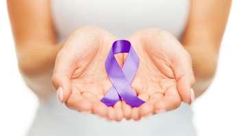 Womans hands holding purple domestic violence awareness ribbon. (© Can Stock Photo / dolgachov)