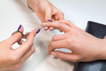 File photo manicurist cutting client's cuticle with nail scissors. Photo courtesy of © Can Stock Photo / ivanriver