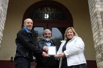 North Huron Reeve Neil Vincent, middle, is joined by Huron-Bruce MPP Lisa Thompson, to his left, and an Ontario Trillium representative to receive a plaque commemorating the $30,000 of funding going towards the Wingham Town Hall Theatre renovations.
